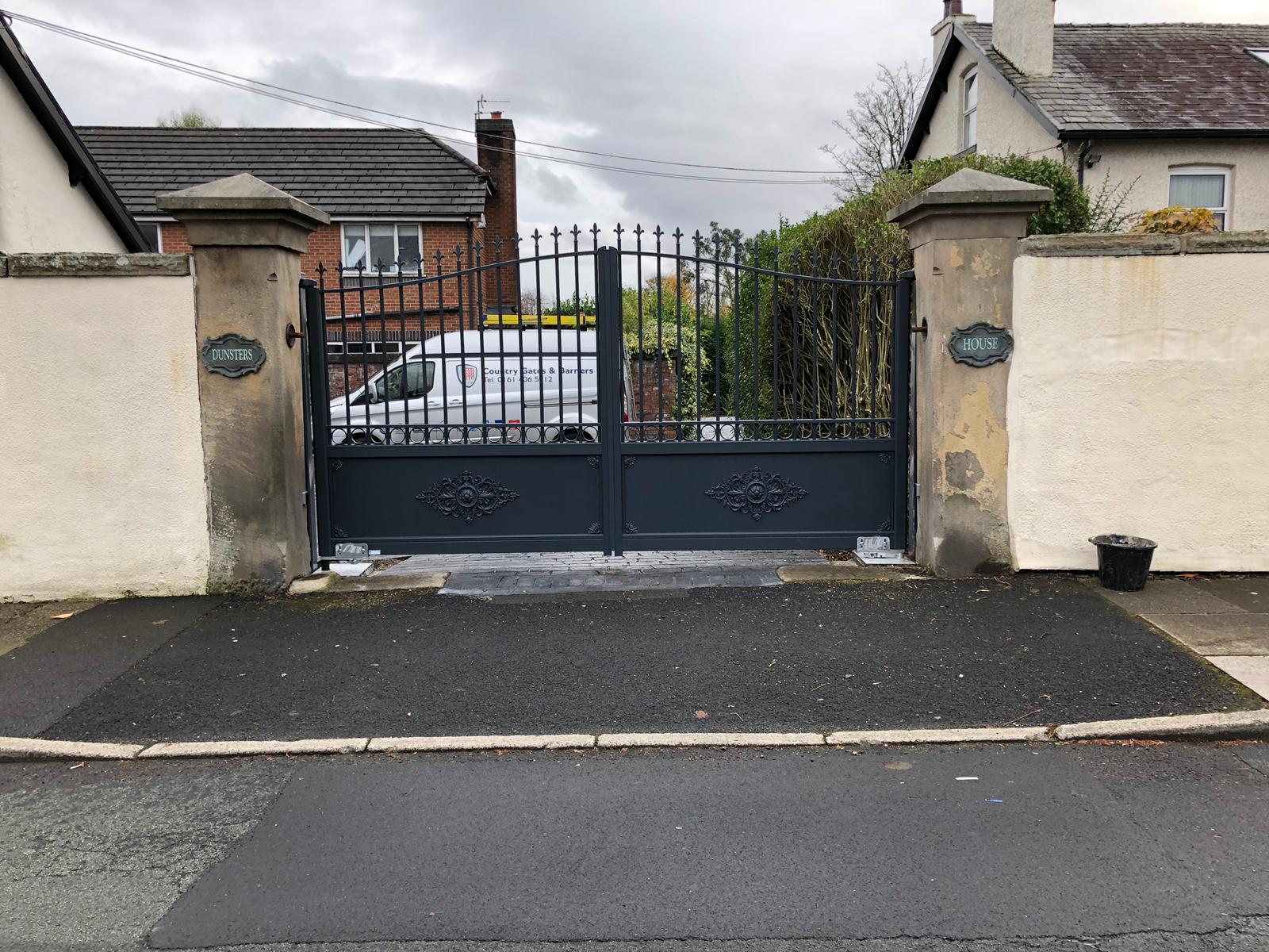 Aluminium gates traditional wrought iron replica style fixed to cream pillars with render